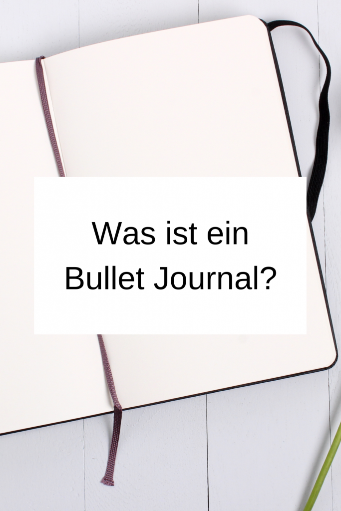 Pinterest-Pin: Was ist ein Bullet Journal. Im Hintergrund ist ein aufgeschlagenes Notizbuch zu sehen. 