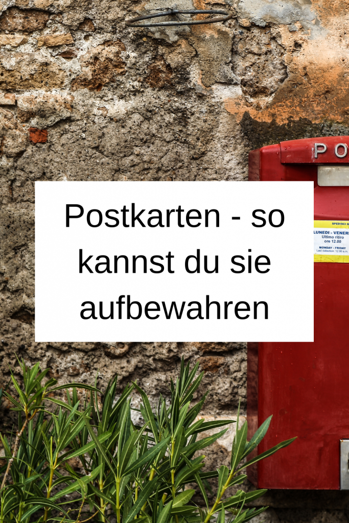 Pinterest-Pin: Postkarten - so kannst du sie aufbewahren. Im Hintergrund ist ein roter Briefkasten vor einer grauen Steinwand zu sehen. 