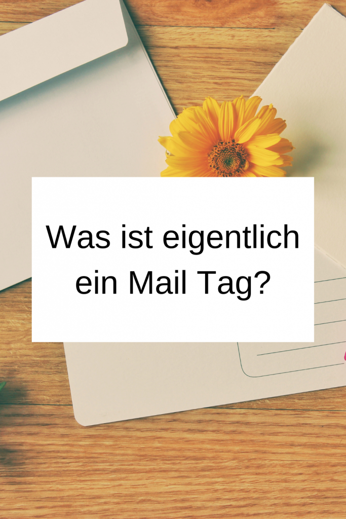 Pinterest-Pin: Was ist eigentlich ein Mail Tag? Auf einem hölzernen Hintergrund sind zwei Briefumschläge und eine gelbe Blume zu sehen. 